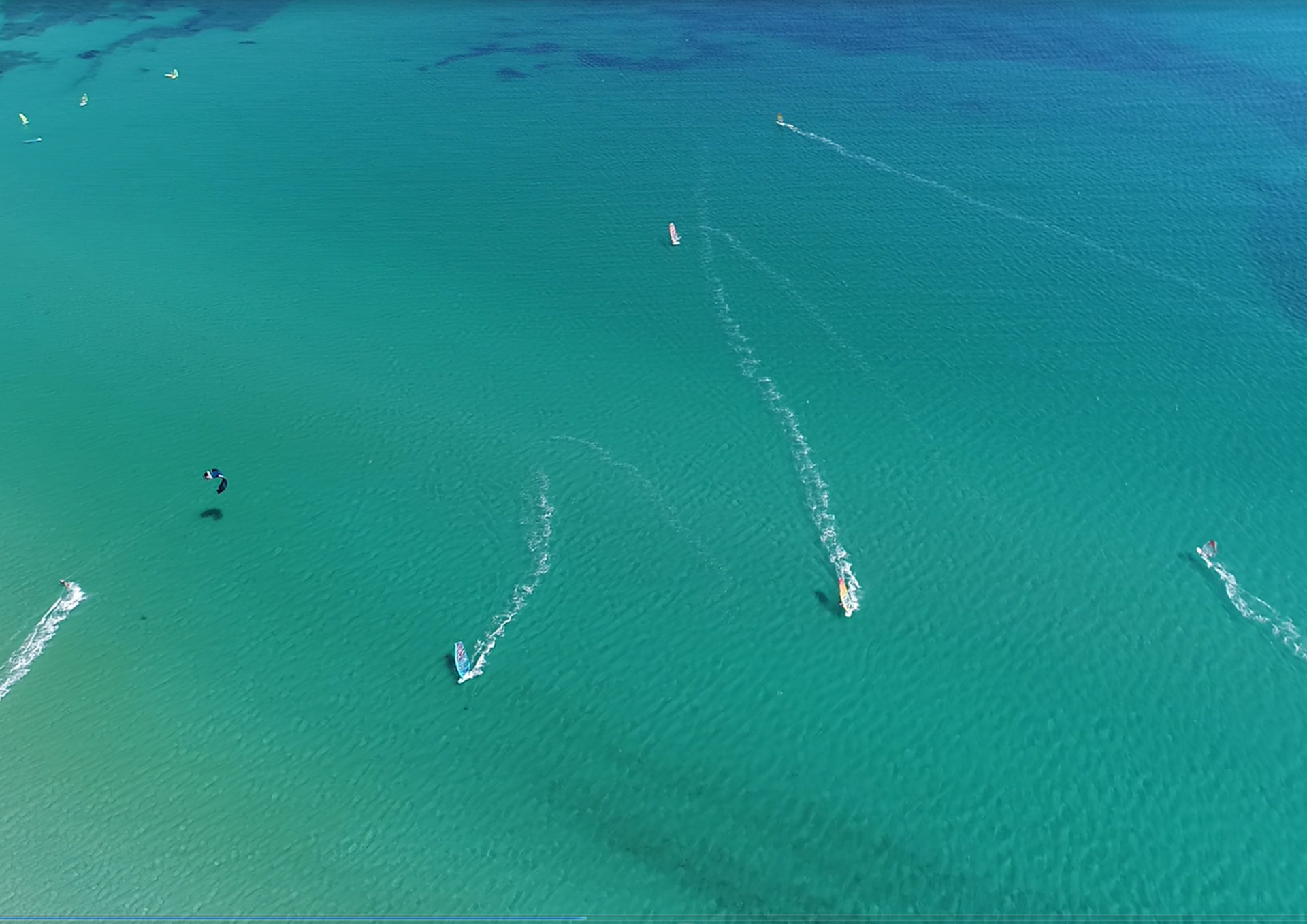 Aerial view of windsurfers on clear turquoise water